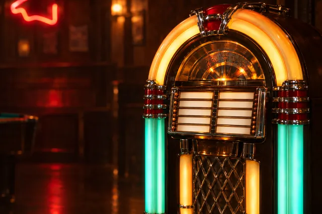 Bella's vintage jukebox glowing amber and teal in the dark bar.